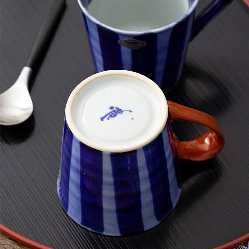 Japan imports Arita ware hand-painted blue & white striped mug with orange handle.