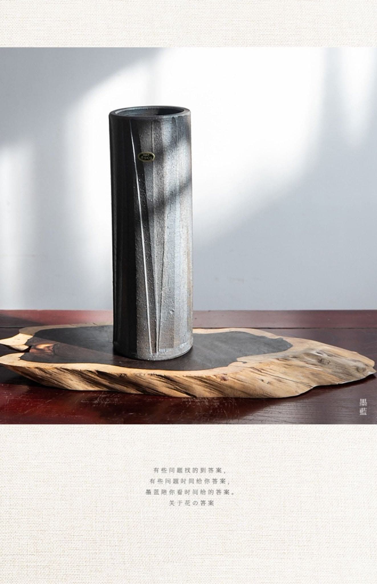 Lead-colored Shigaraki ceramic vase with textured vertical lines on a wooden base.