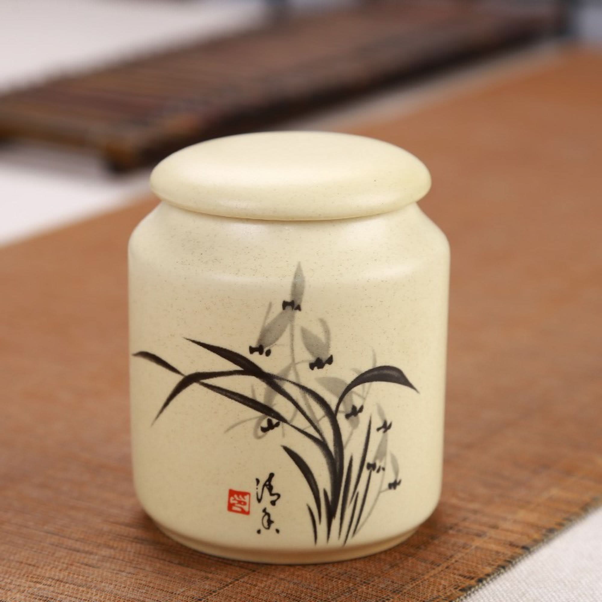 Cream Japanese art ceramic tea container with painted reeds and a red seal, perfect for storage.
