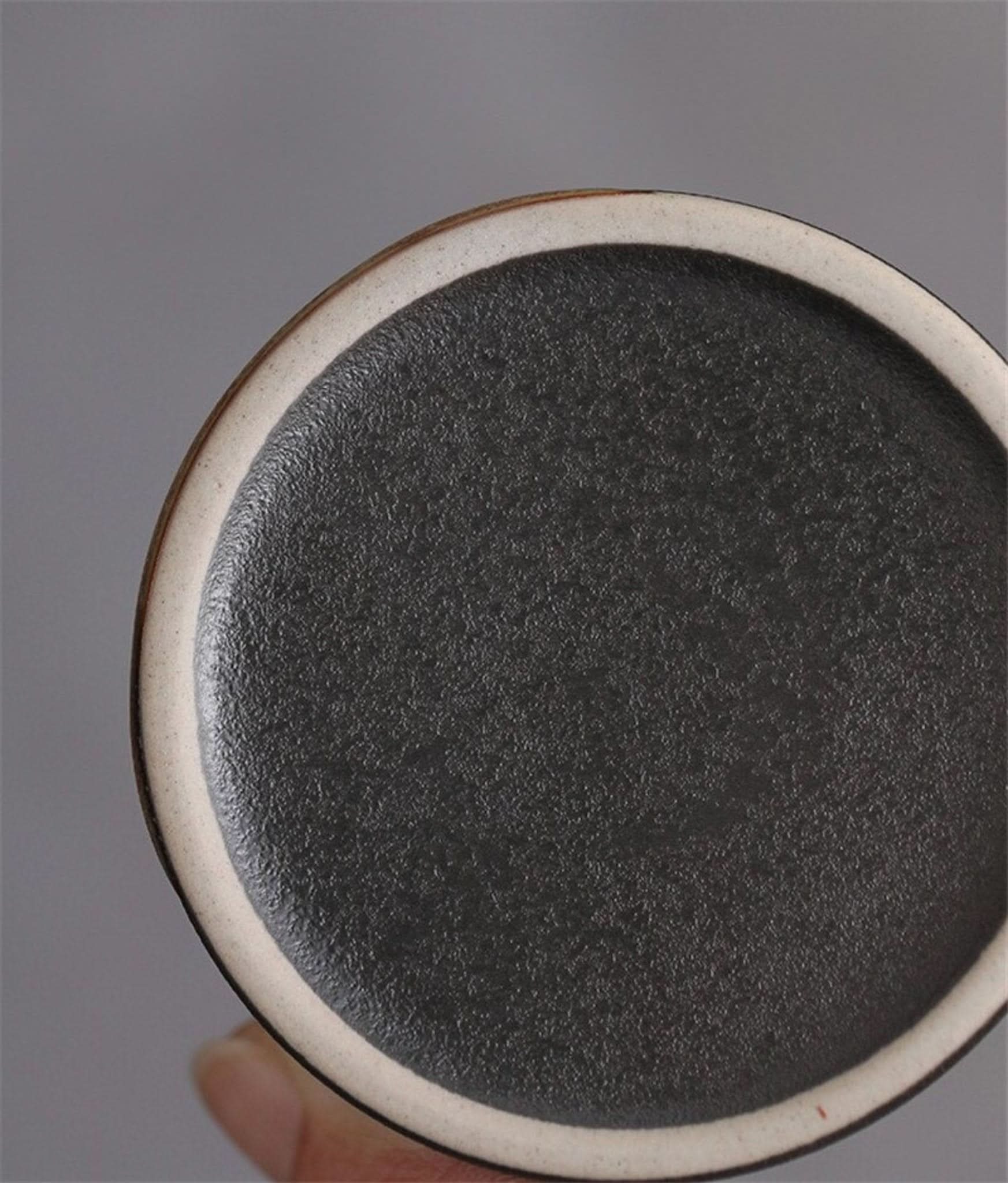 Ceramic tea canister, matt black finish with off-white rim detail.