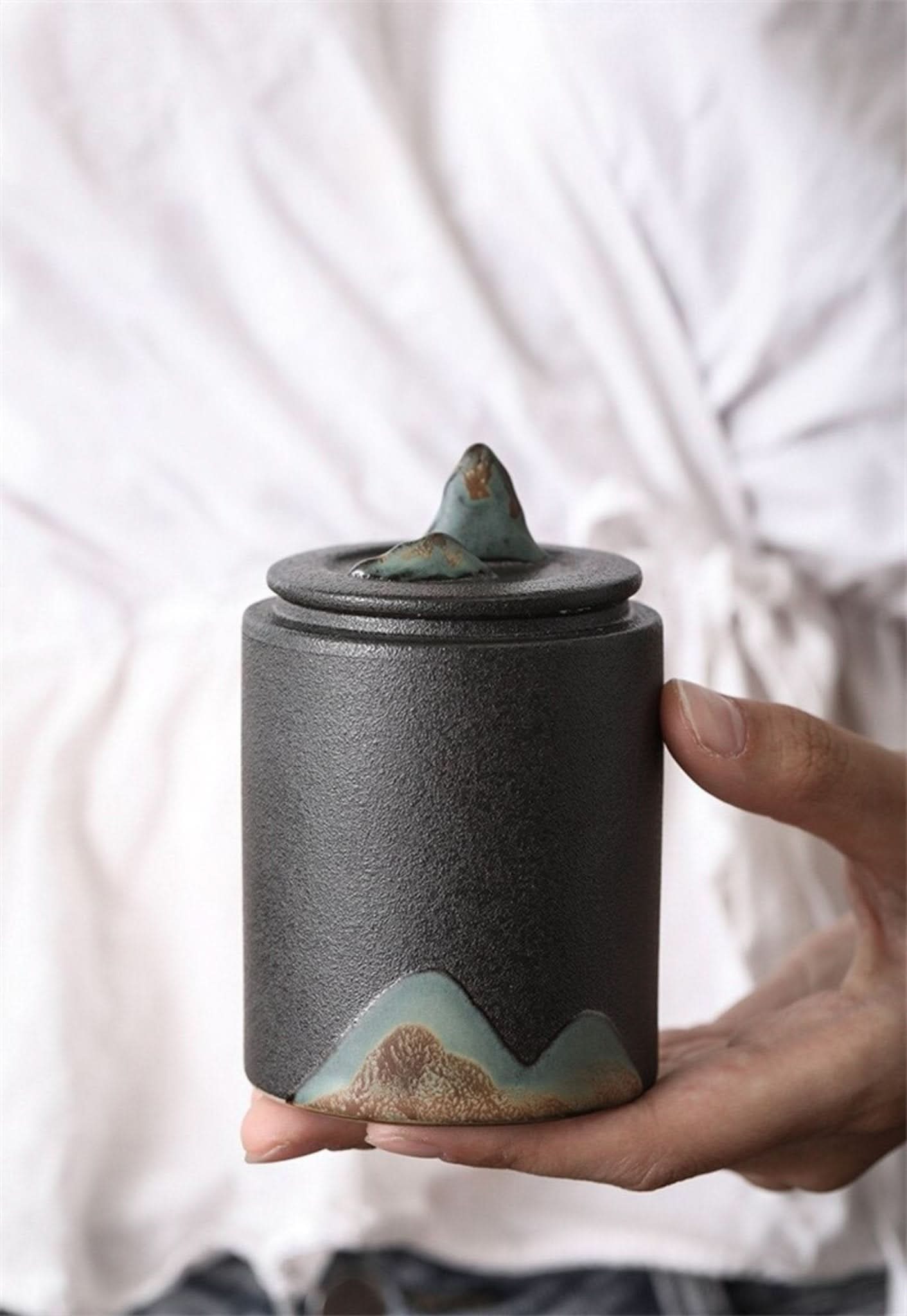 Matte black ceramic tea canister with mountain design and unique lid, home decor