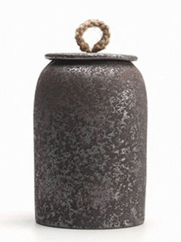 Rustic brown ceramic tea canister with cord lid on white background.