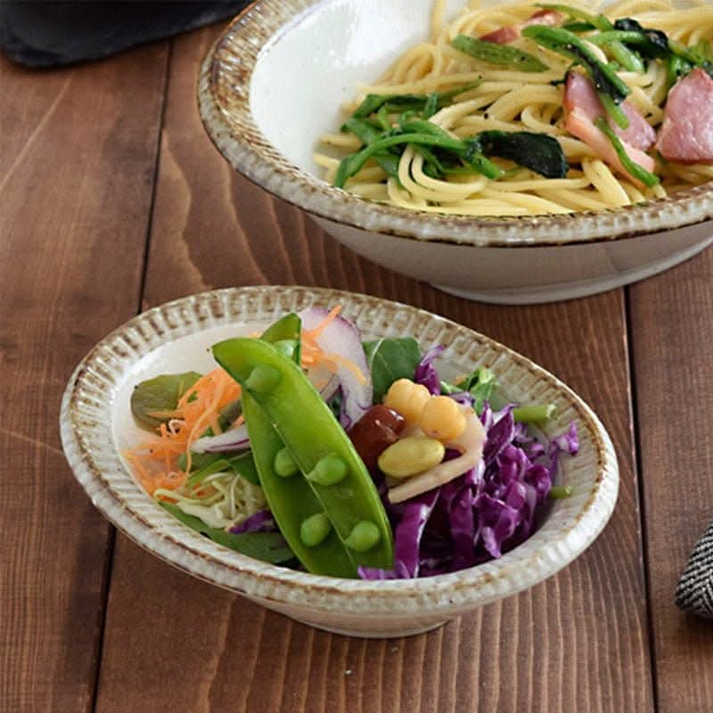 Japanese Tableware Handmade Set featuring a salad with peas and pasta with spinach on a wooden table.