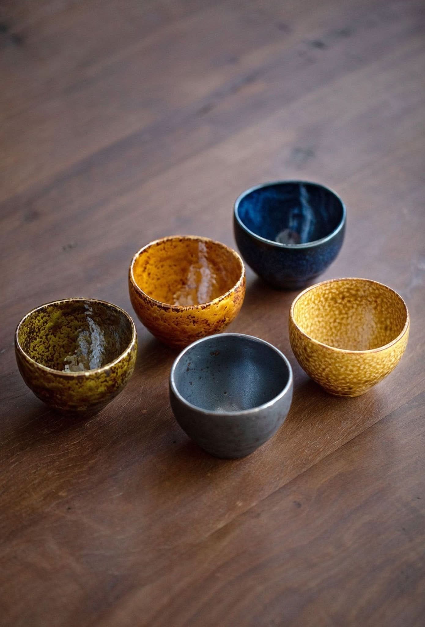 Japanese-Imported Glazed Tea Cup 5 Set: Ceramic tea ceremony cups in blue, gold, and green on wood.