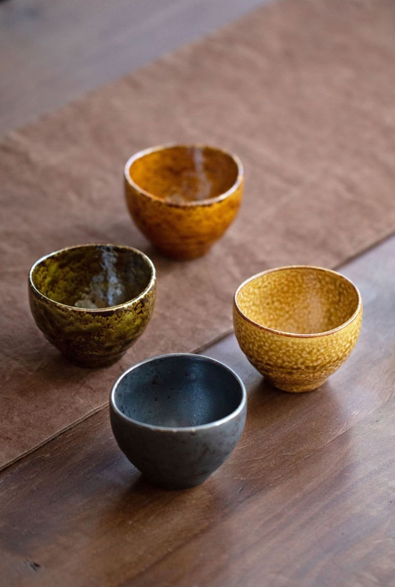 Japanese-Imported Glazed Tea Cup 5 Set: warm ceramic pottery in amber, gold, and charcoal hues.