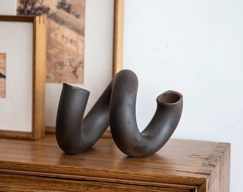 Dark ceramic irregular spiral vase, Japanese imported home decor on wooden surface.