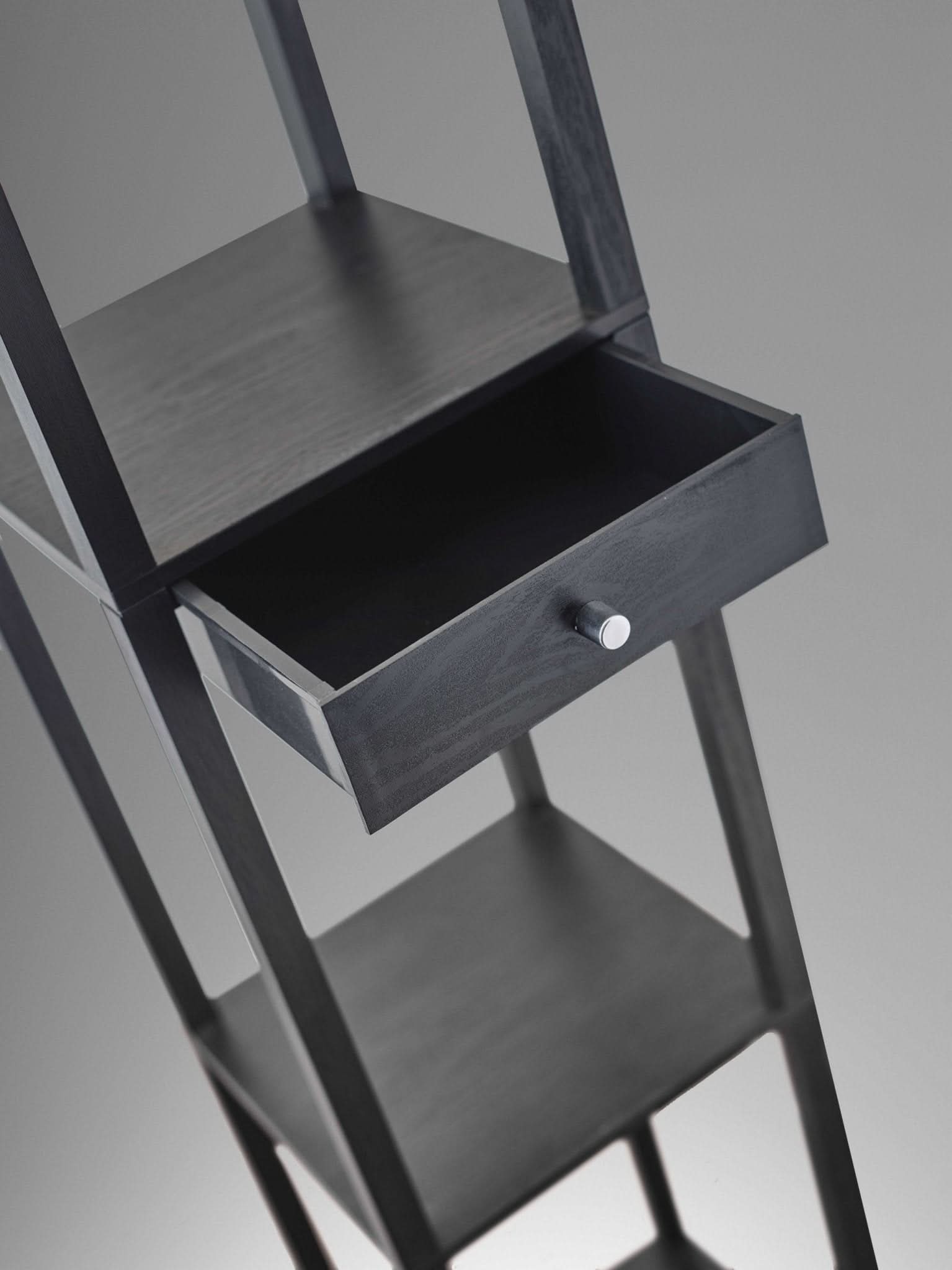 Dark wood Japanese inspired floor lamp with open storage drawer on grey background.