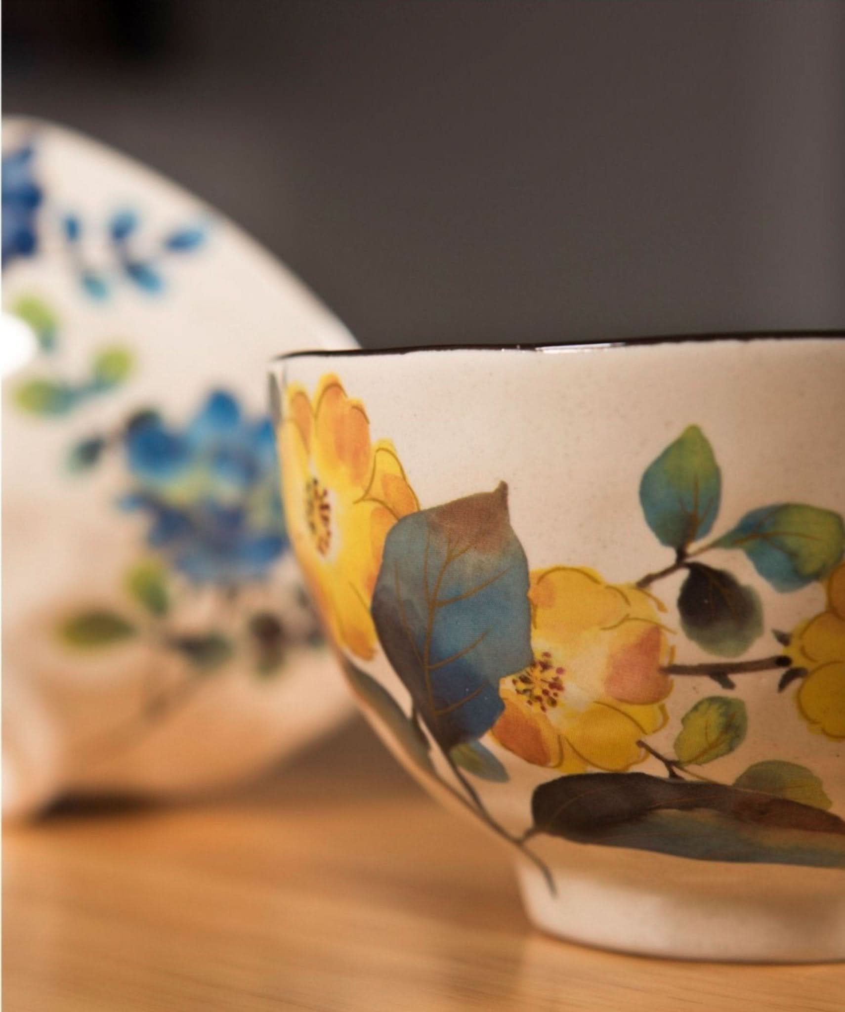 Japanese rice bowl set with yellow and blue floral design on cream ceramic.