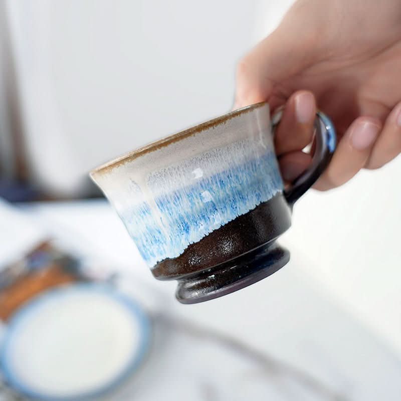Japanese Stoneware 3 Tone Glazed Mug With Coasters, held by hand, white, blue & brown glaze.