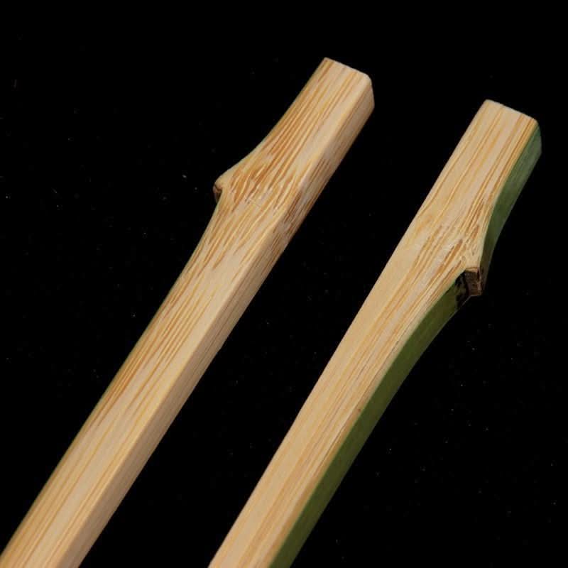 Natural bamboo Japanese style chopsticks with unique knot details on black background.
