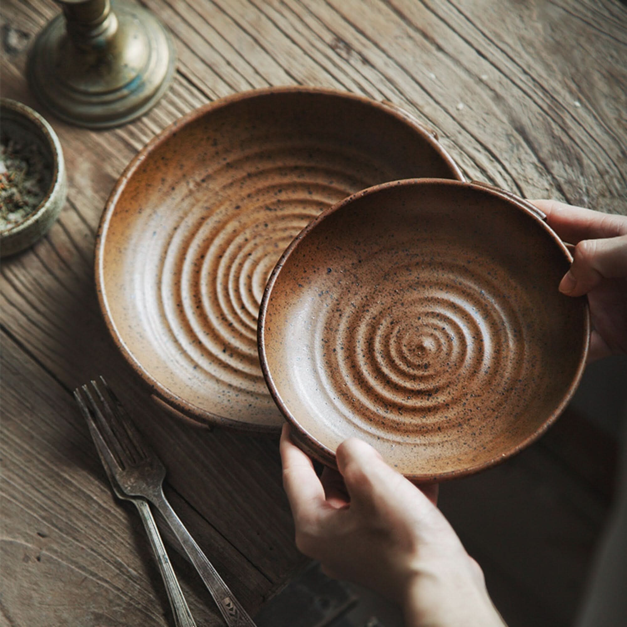 Rustic Dinnerware Brown Speckled ceramic plates on a wooden table with forks and decor.