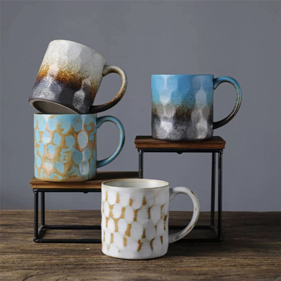 Japanese style ceramic coffee cup retro mug in blue, white, and earth tones. Textured finish.