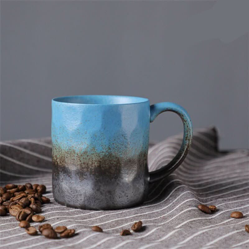 Japanese style ceramic coffee cup, retro mug with blue and gray gradient glaze, sits on striped cloth.