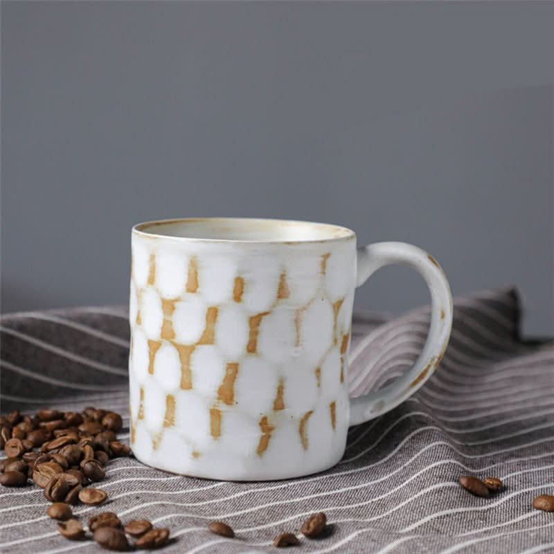 Japanese style ceramic coffee cup retro mug with textured pattern and coffee beans on striped cloth.