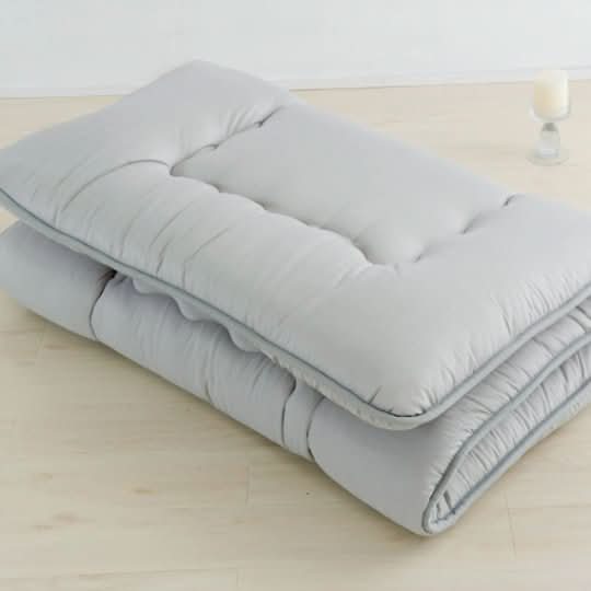 Gray Japanese Style Floor Mattress on light wood floor, soft tufted design, home decor essential.
