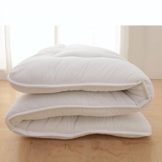 White Japanese Style Floor Mattress folded on a light wood floor with soft natural light.