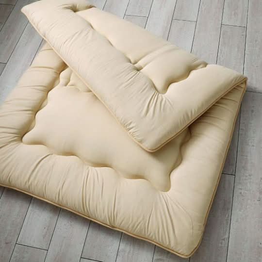 Cream Japanese Style Floor Mattress on light wood floor. Quilted, plush comfort.