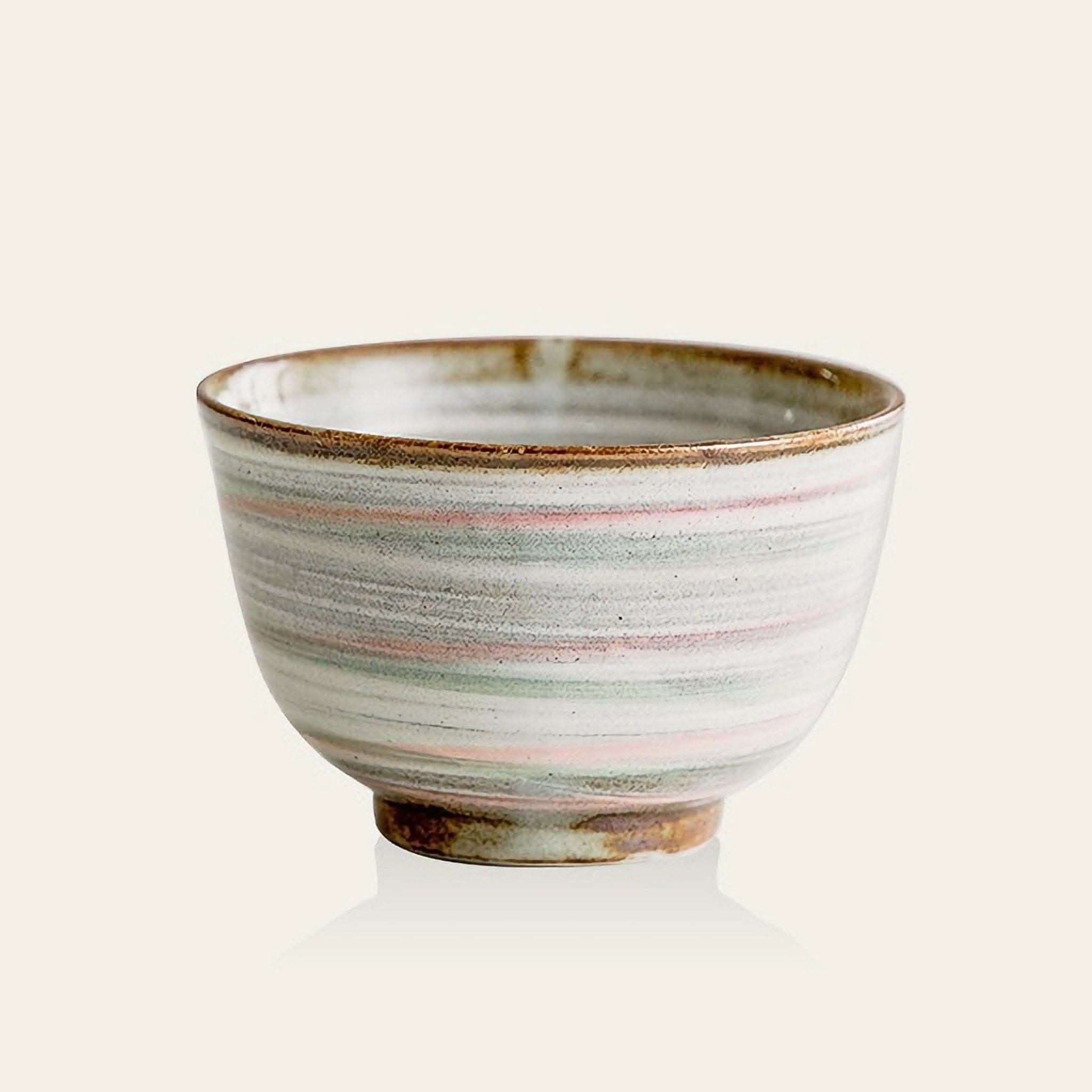 Handmade Japanese Minoyaki rice bowl with subtle pink, green, and gray stripes and rustic ceramic base.