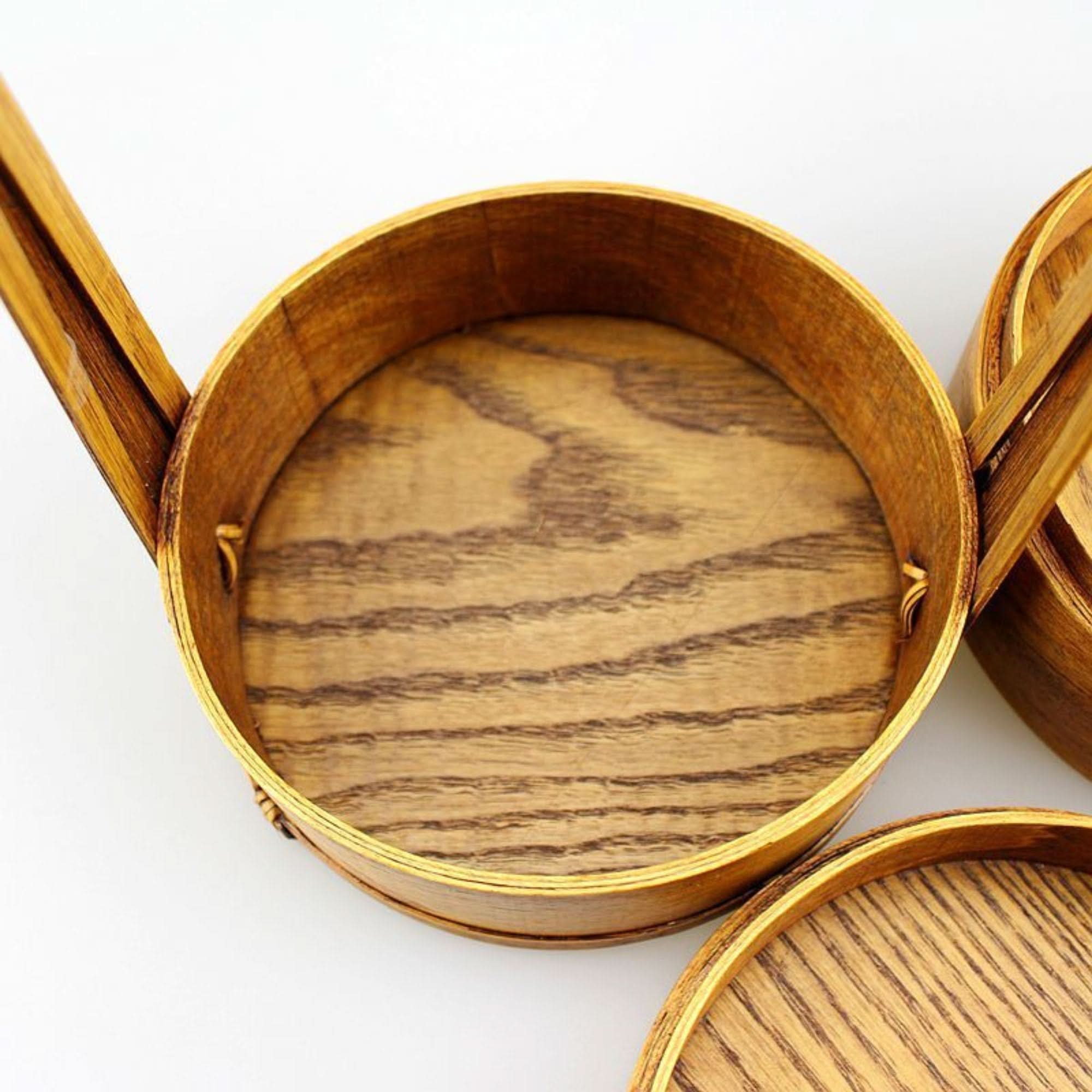Natural wood Japanese lunch box with visible grain, on a white background.