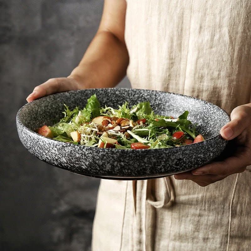 Japanese-style ceramic deep dish salad bowl with speckled granite finish, holding fresh salad.