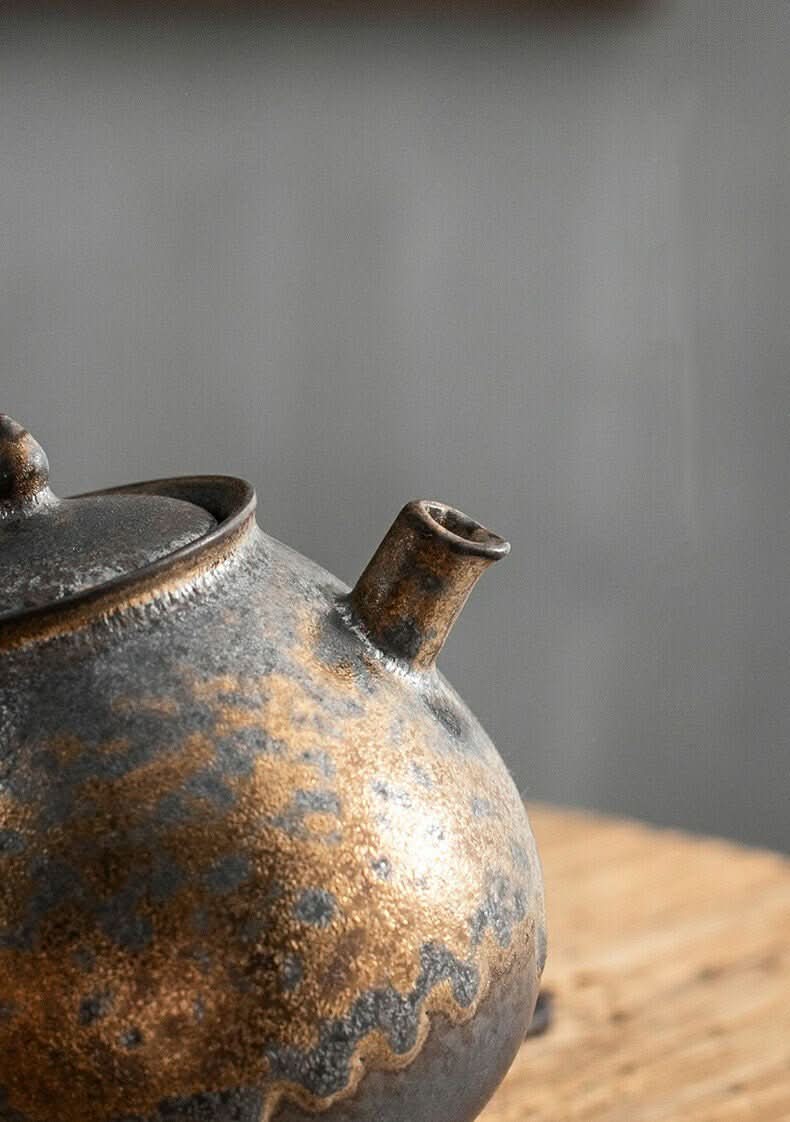 Japanese Style Stoneware Gilt Glazed Teapot with rustic metallic finish on wooden surface.