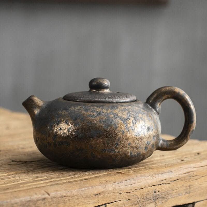 Japanese style stoneware gilt glazed teapot with textured finish, perfect for tea party decorations.