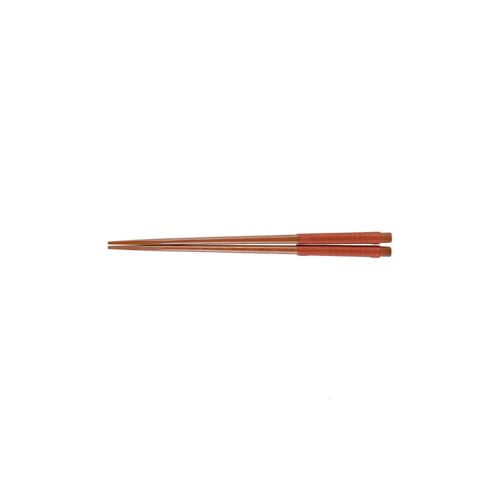 Brown Japanese wooden chopsticks with carved details and red-wrapped handles.
