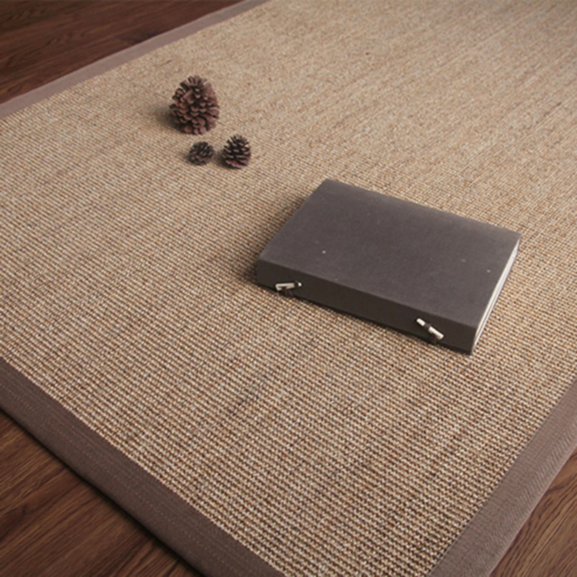 Jug Rug With Covered Borders: Natural fiber rug with brown border on wood floor.