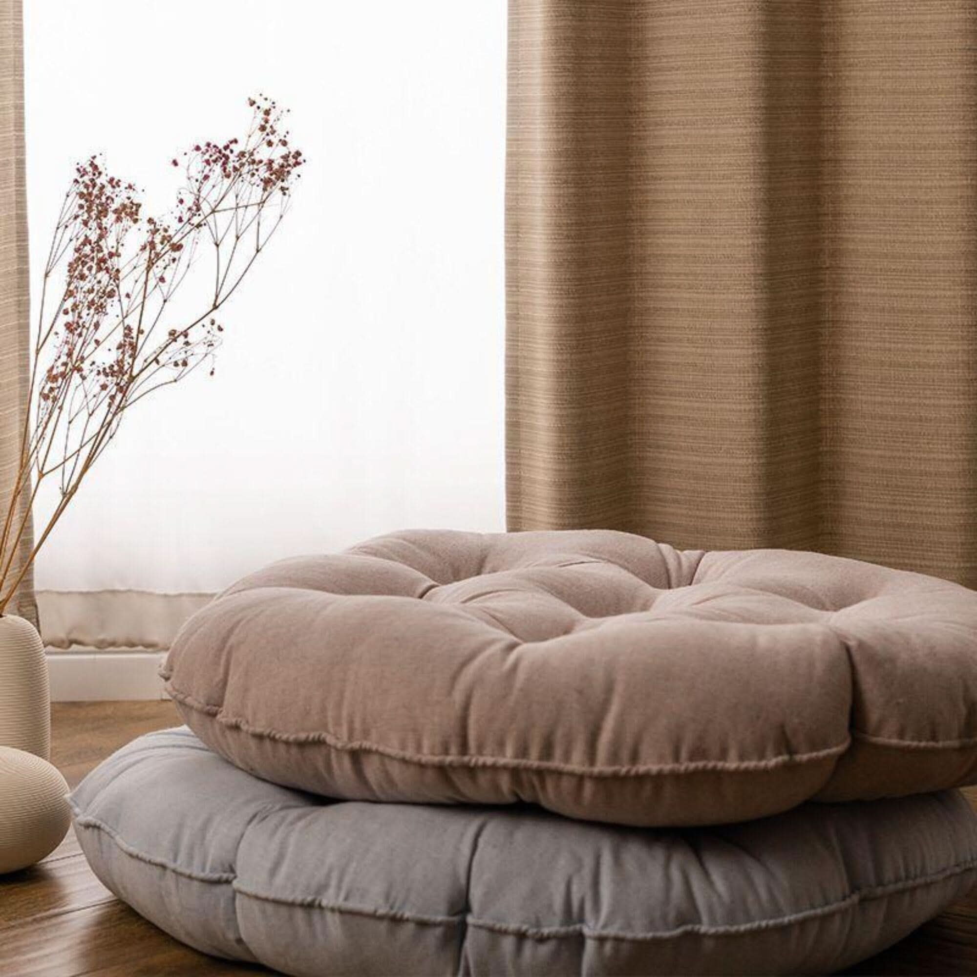 Two tufted linen meditation cushions (23" & 18") in taupe and grey, styled with decor.