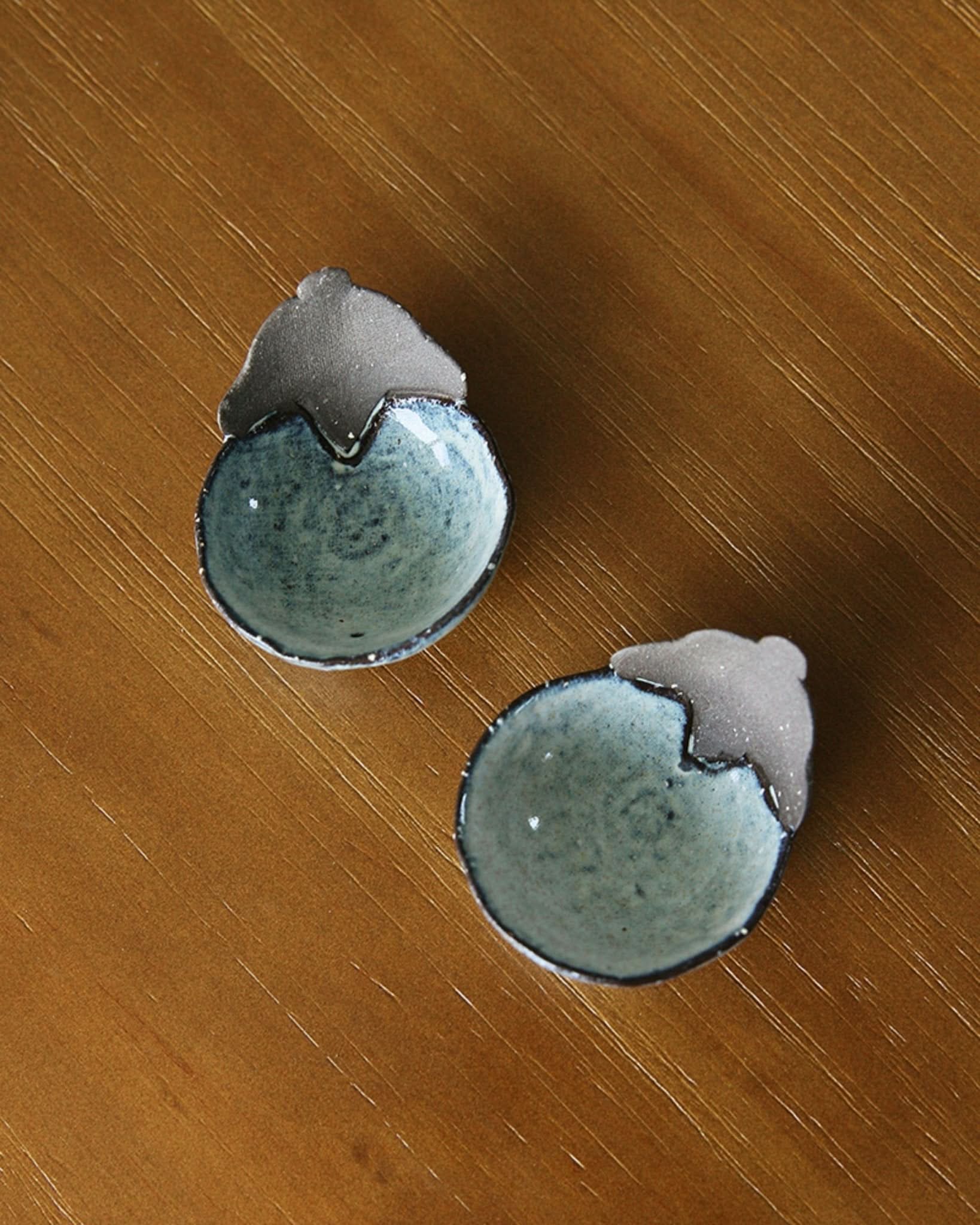 Mino-yaki handmade vegetable-shaped stoneware dip bowls with blue glaze on a wooden surface.