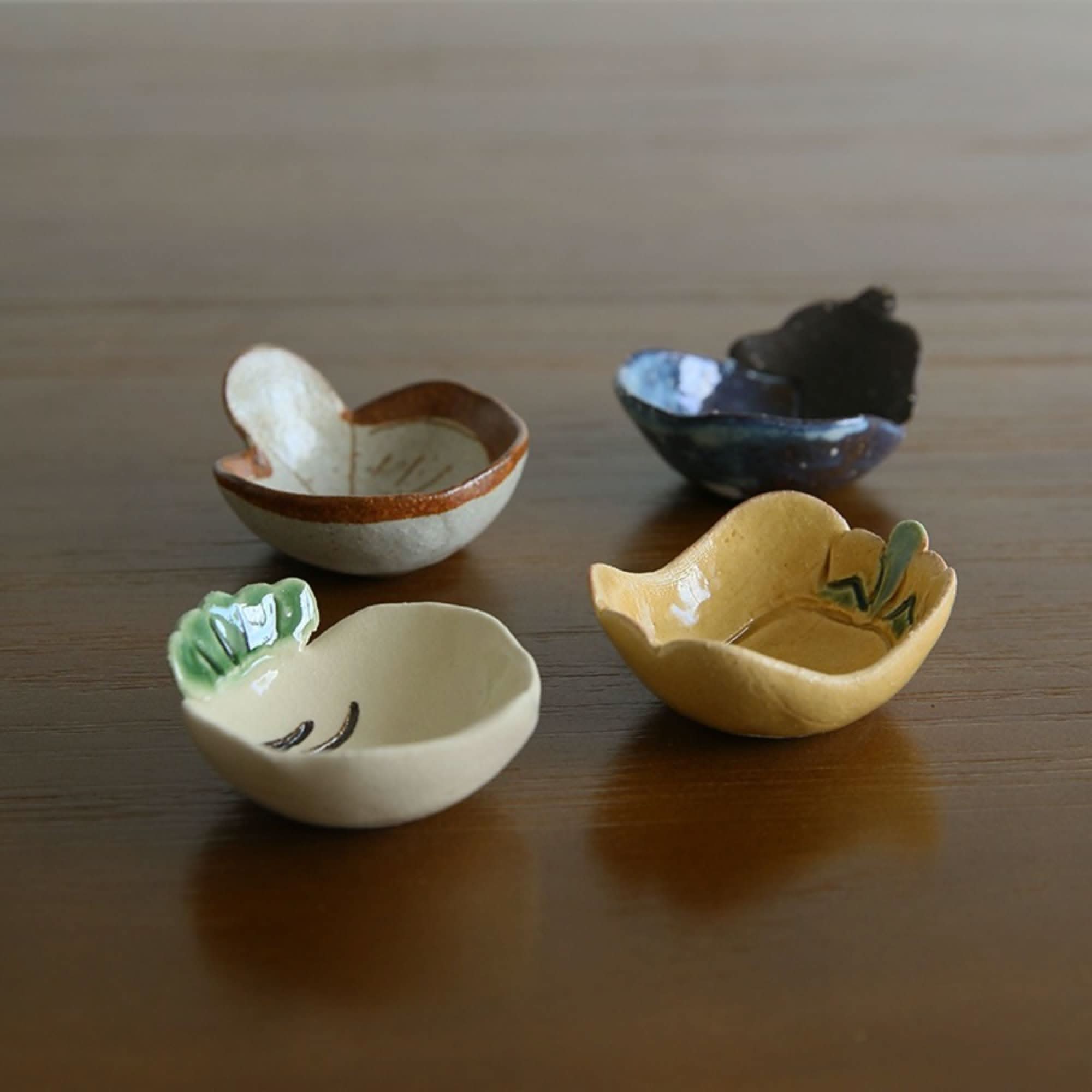 Mino-yaki handmade vegetable dip bowls: stoneware, seasoning dishes in beige, yellow, white, & blue on wood.