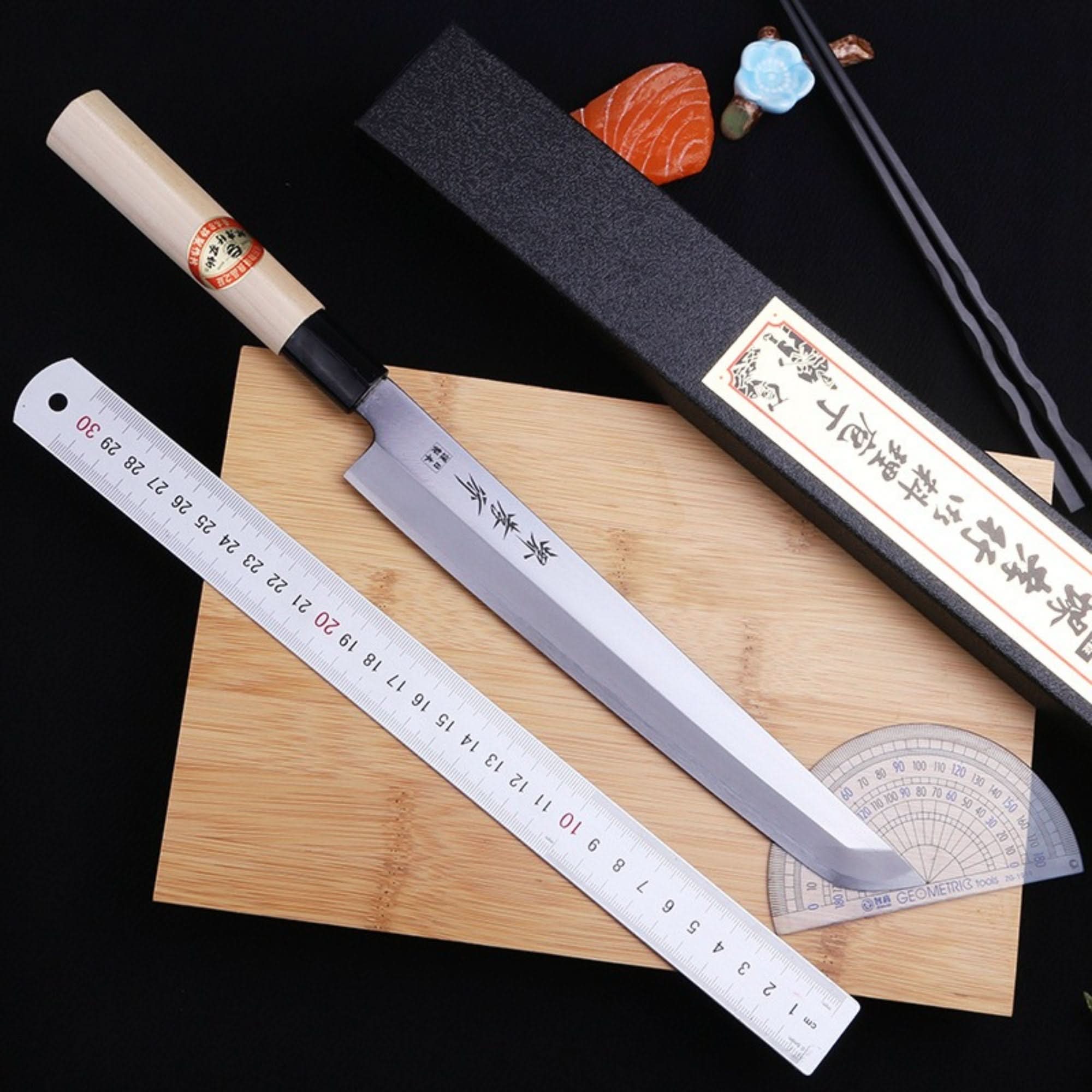 Mukimono Japanese Knife with wooden handle, steel blade, on cutting board.