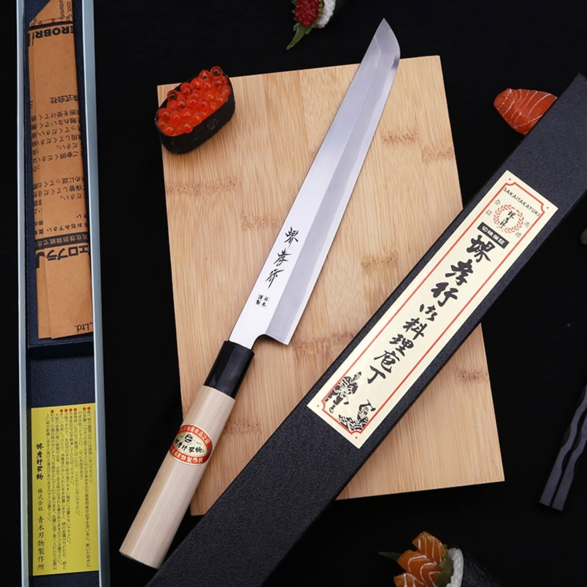 Mukimono Japanese Knife on wood cutting board with sushi garnishes.