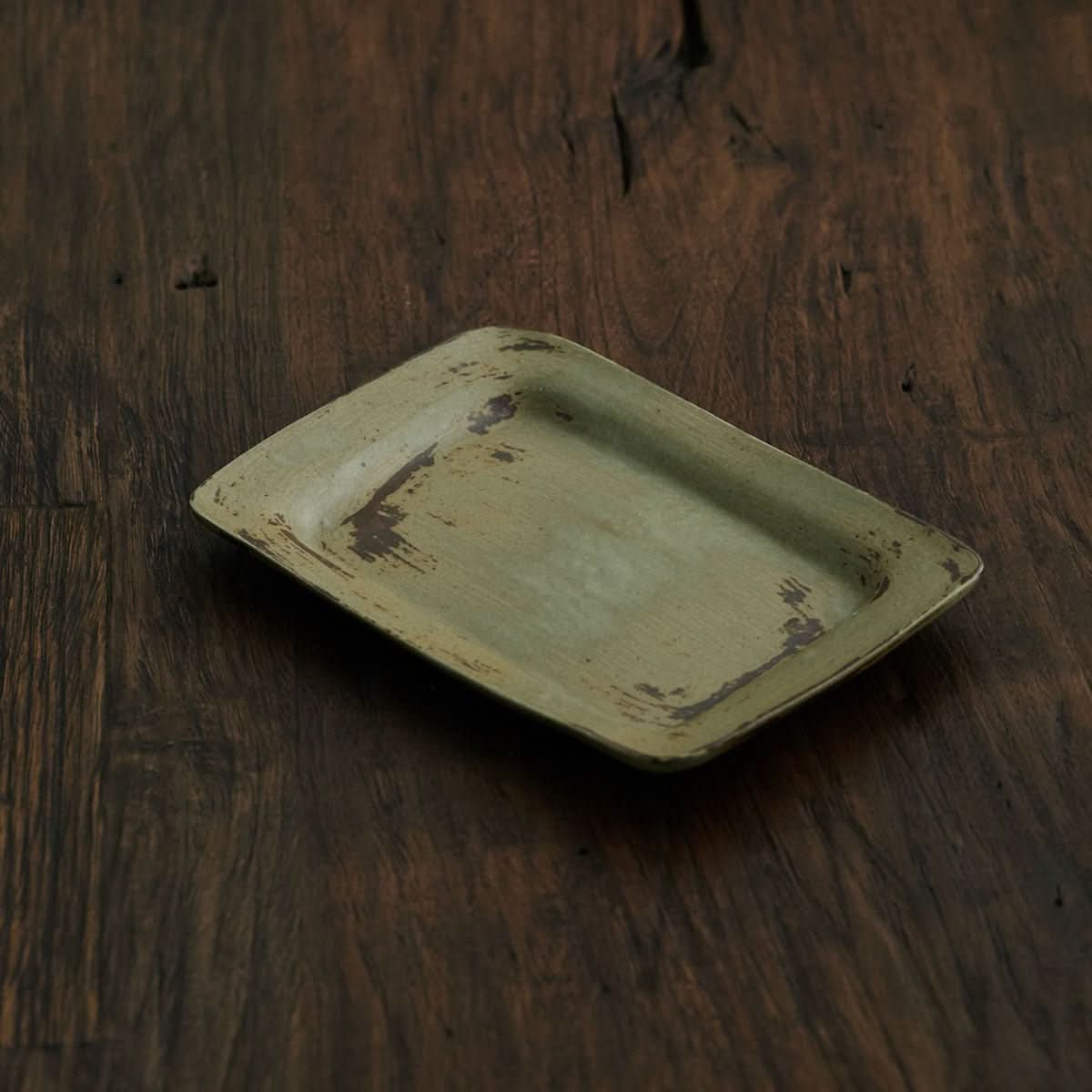 Japanese-style brushed pottery dish, wabi sabi oval retro salad plate on dark wood.