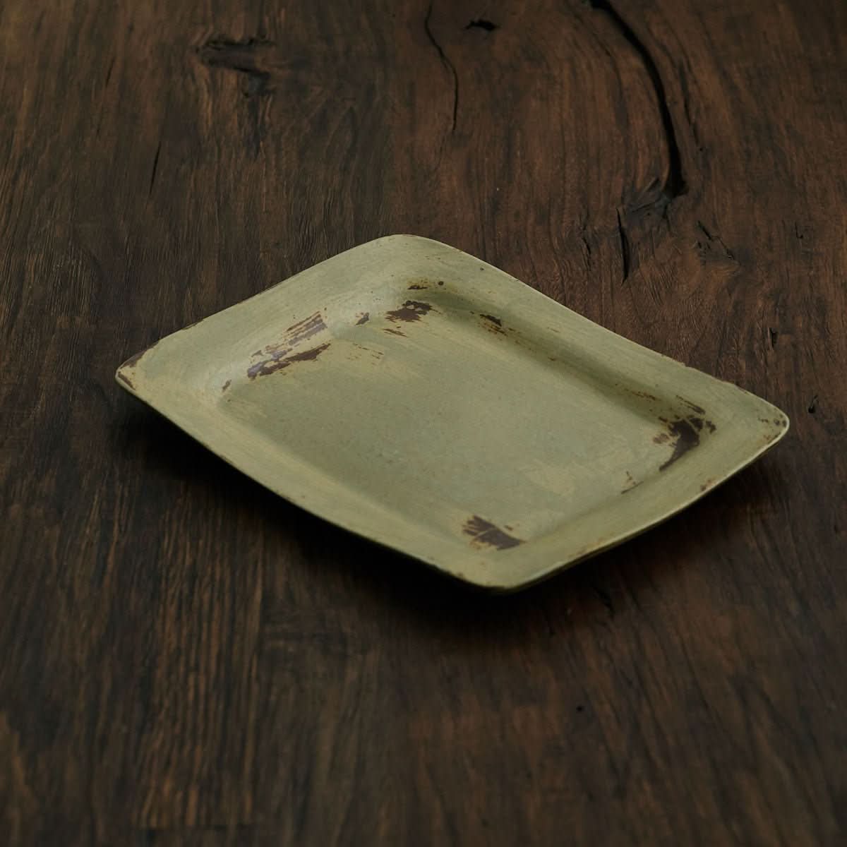 Japanese-style brushed pottery dish, oval retro salad plate with wabi sabi feel on dark wood.