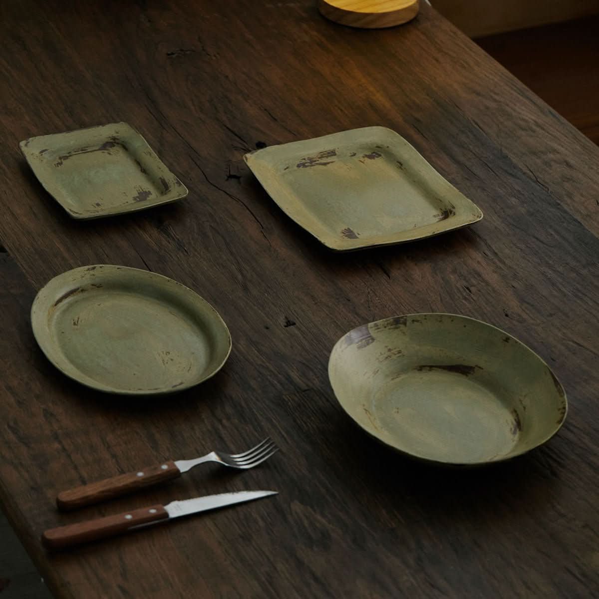 Handmade Japanese brushed pottery dishes, wabi sabi sense, retro oval salad plates on a dark wooden table.