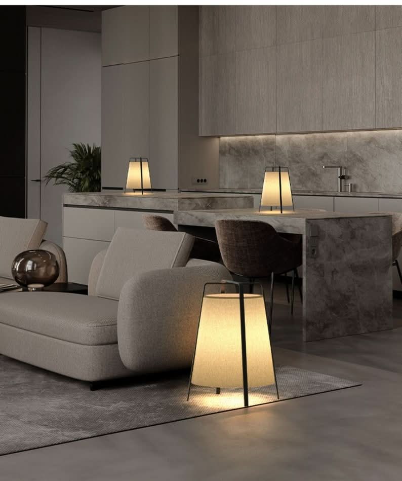 Nordic Lamp With 3 Legs, cone shape table lamp on grey rug next to couch.