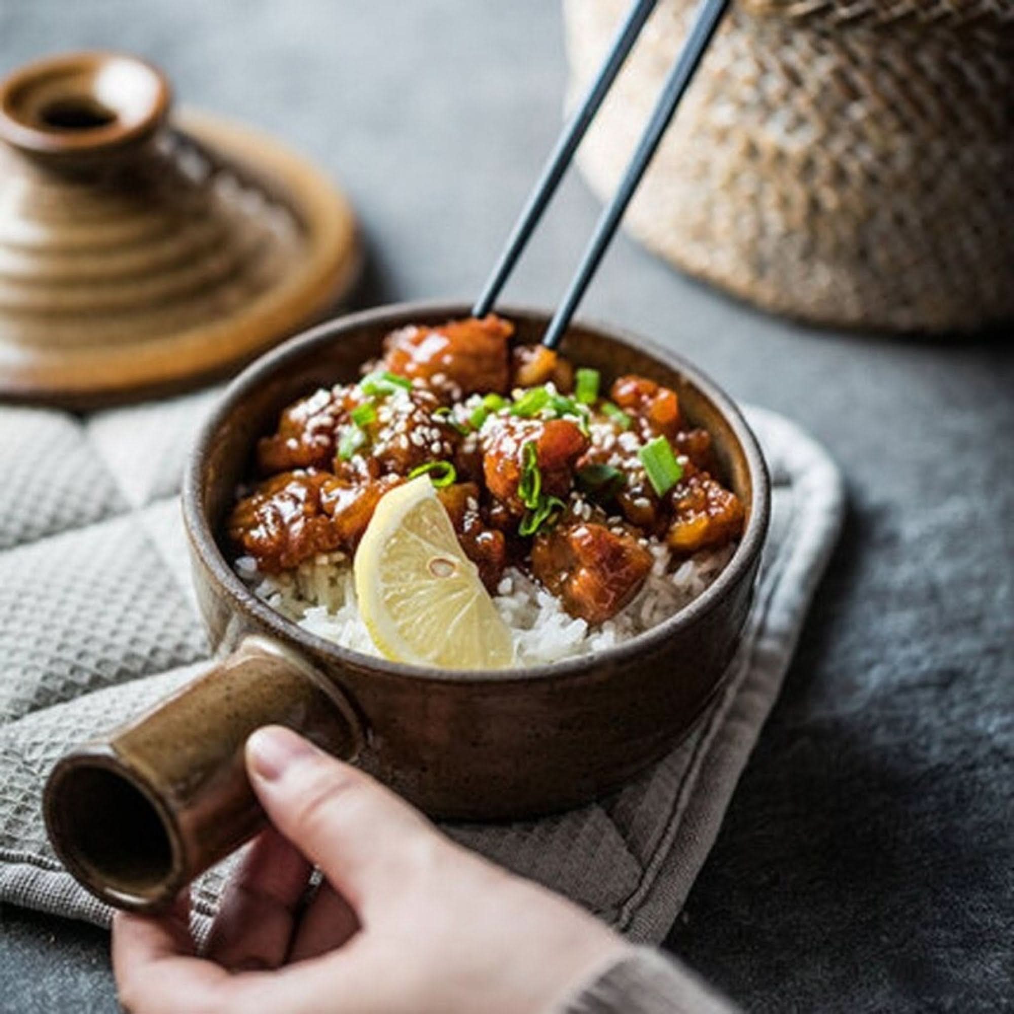 Rustic Nordic stoneware glazed baking plate holding a dish with rice, chicken, and lemon.