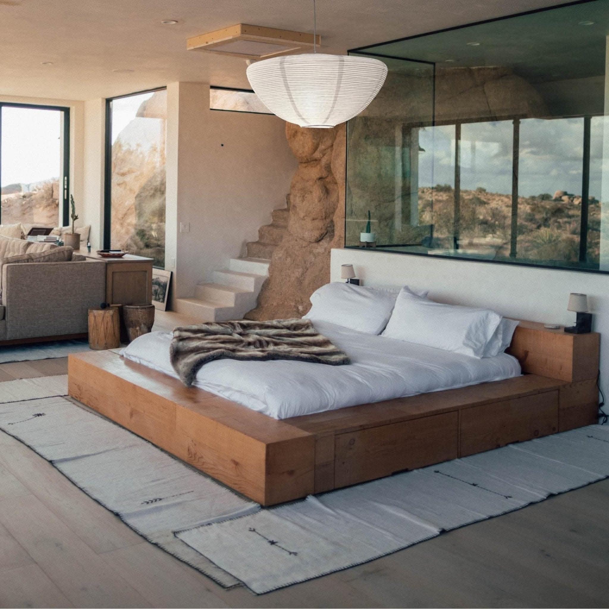 White oval paper lampshade hanging over a wooden bed, natural home decor.