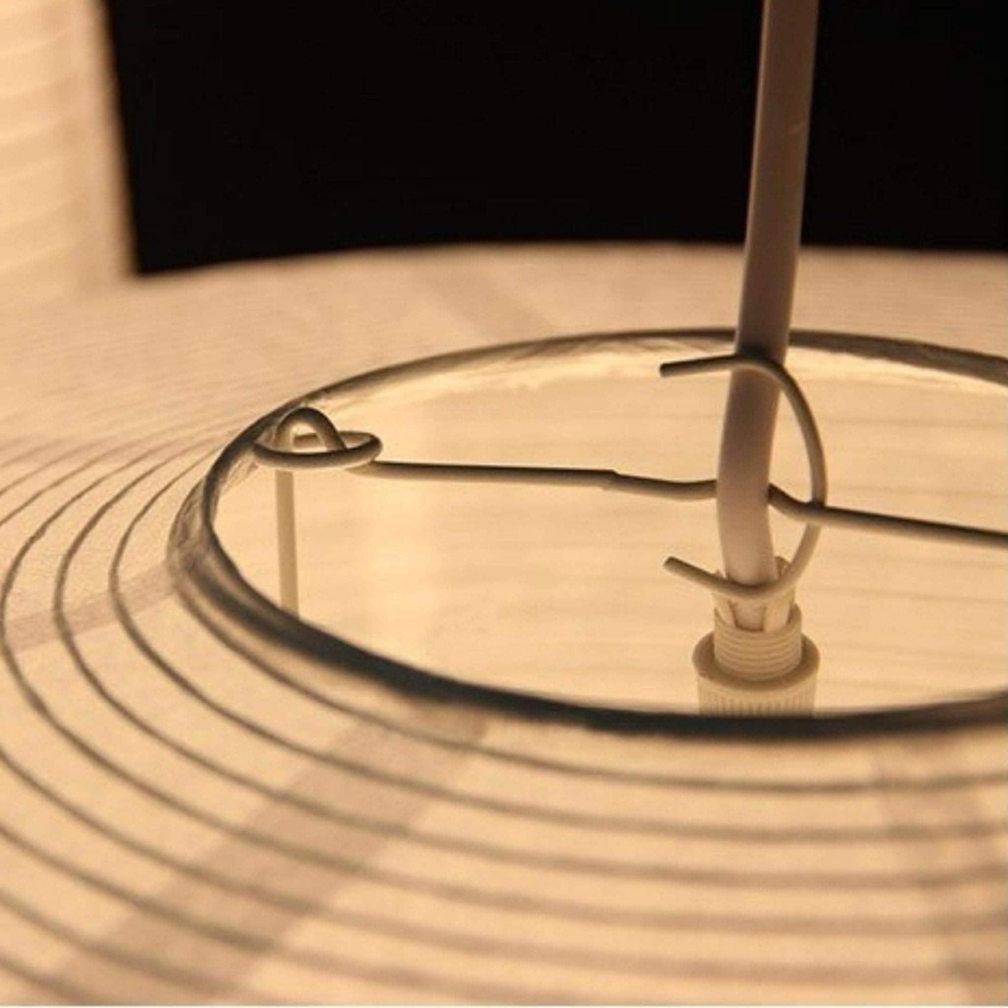 Close-up of Paper Lampshade Oval Shape in cream with black lines, showing wire frame and bulb socket.
