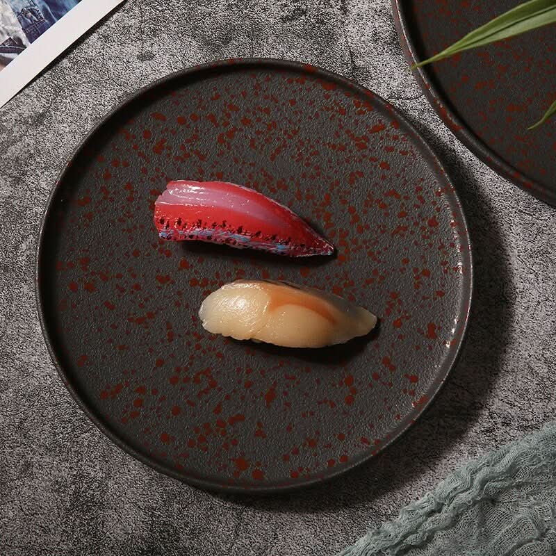 Oxid Metal Look Ceramic Plates: Rustic glazed, round, matte Japanese plates with sushi.