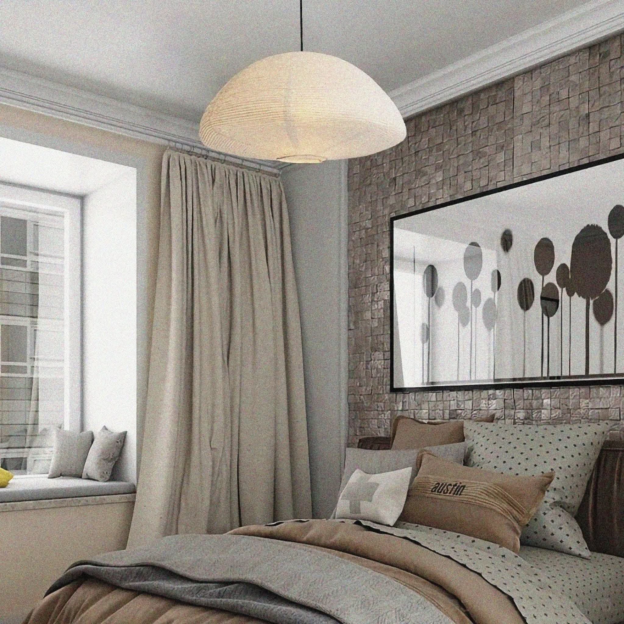 Neutral paper lampshade half circle shaped hanging above a bed with muted tone decor.