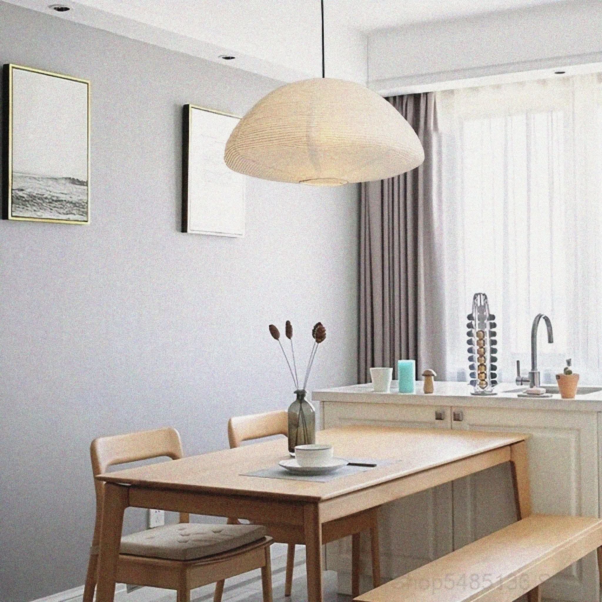 Neutral paper lampshade half circle shaped hanging above a wood dining set in a modern room.