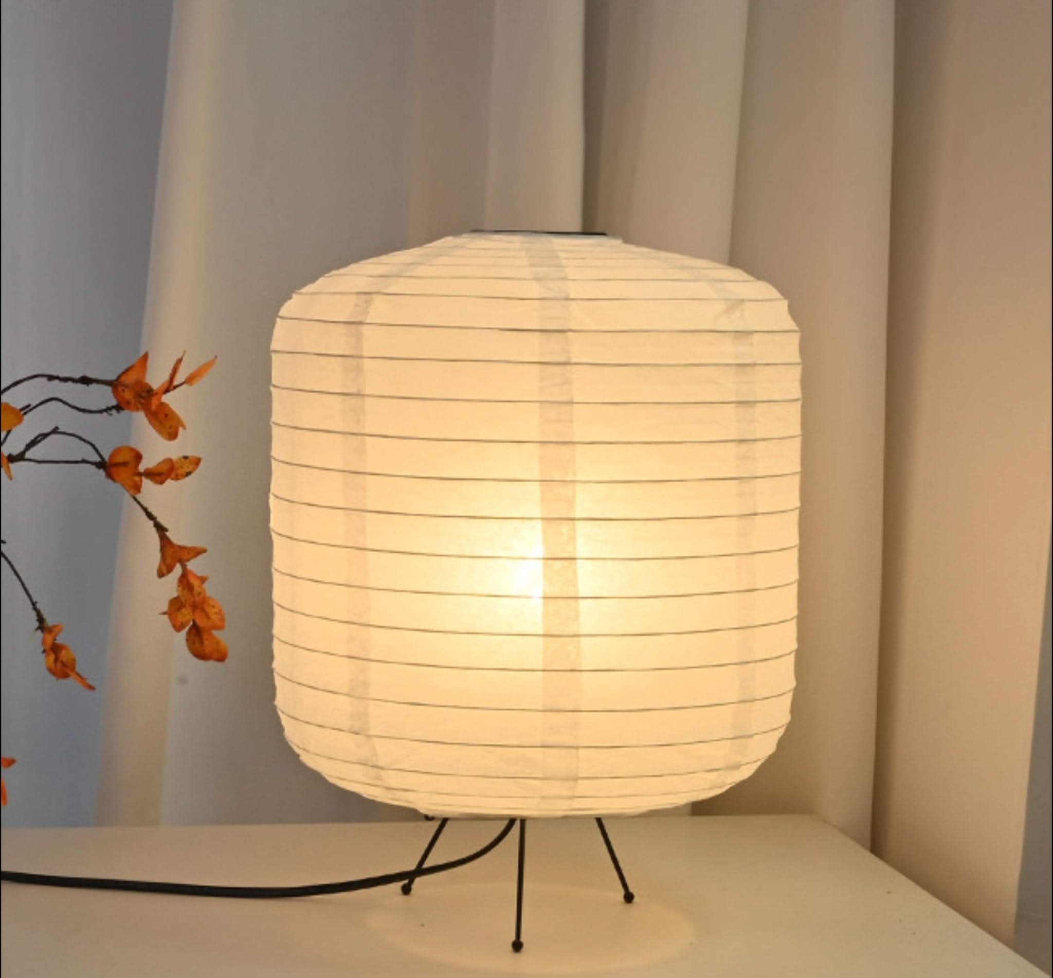 Illuminated Paper Table Lamp with cylinder rounded shape in a home decor setting.