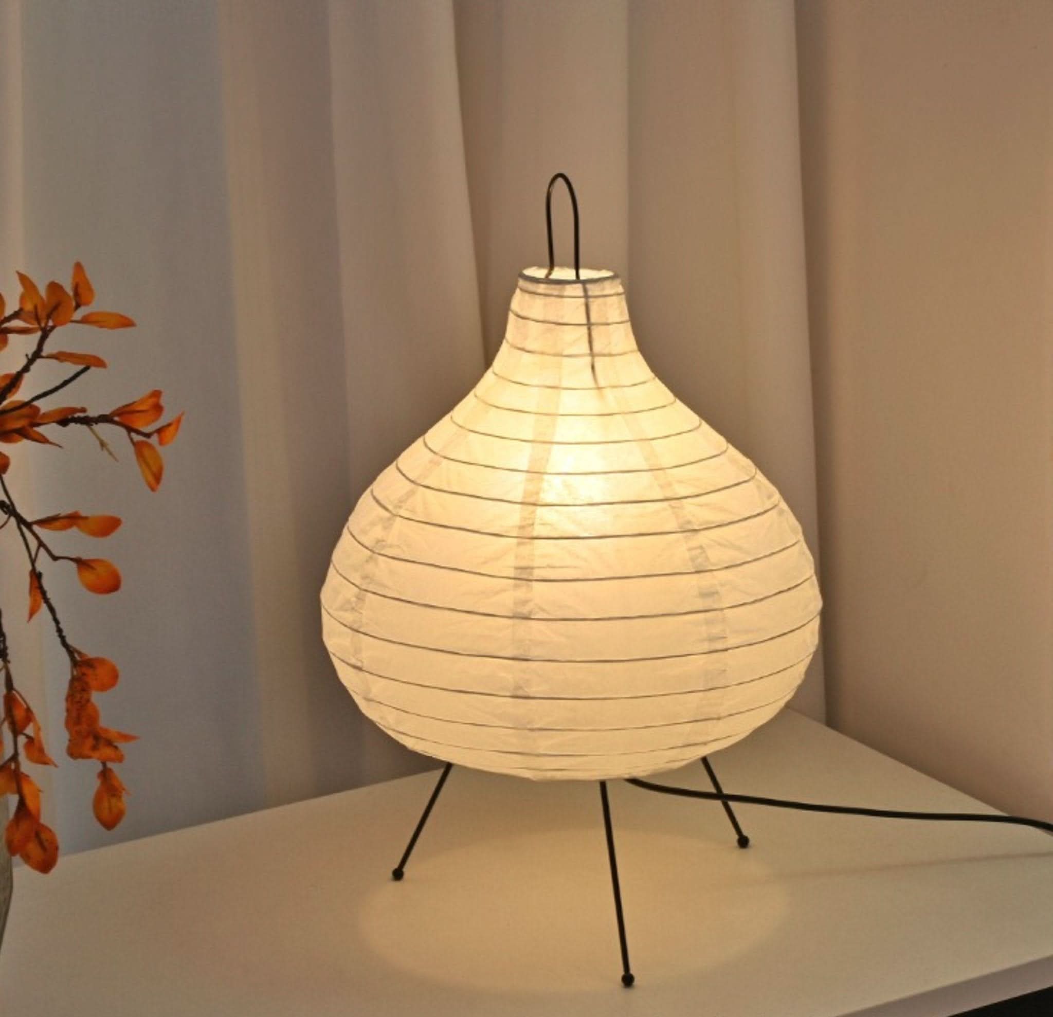 Paper Table Lamp, Garlic Shape, on a white surface with floral decor.