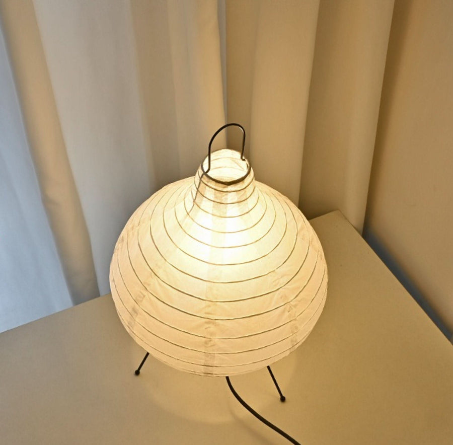 Paper table lamp, garlic shape, with mid-century Asian design on a white surface.