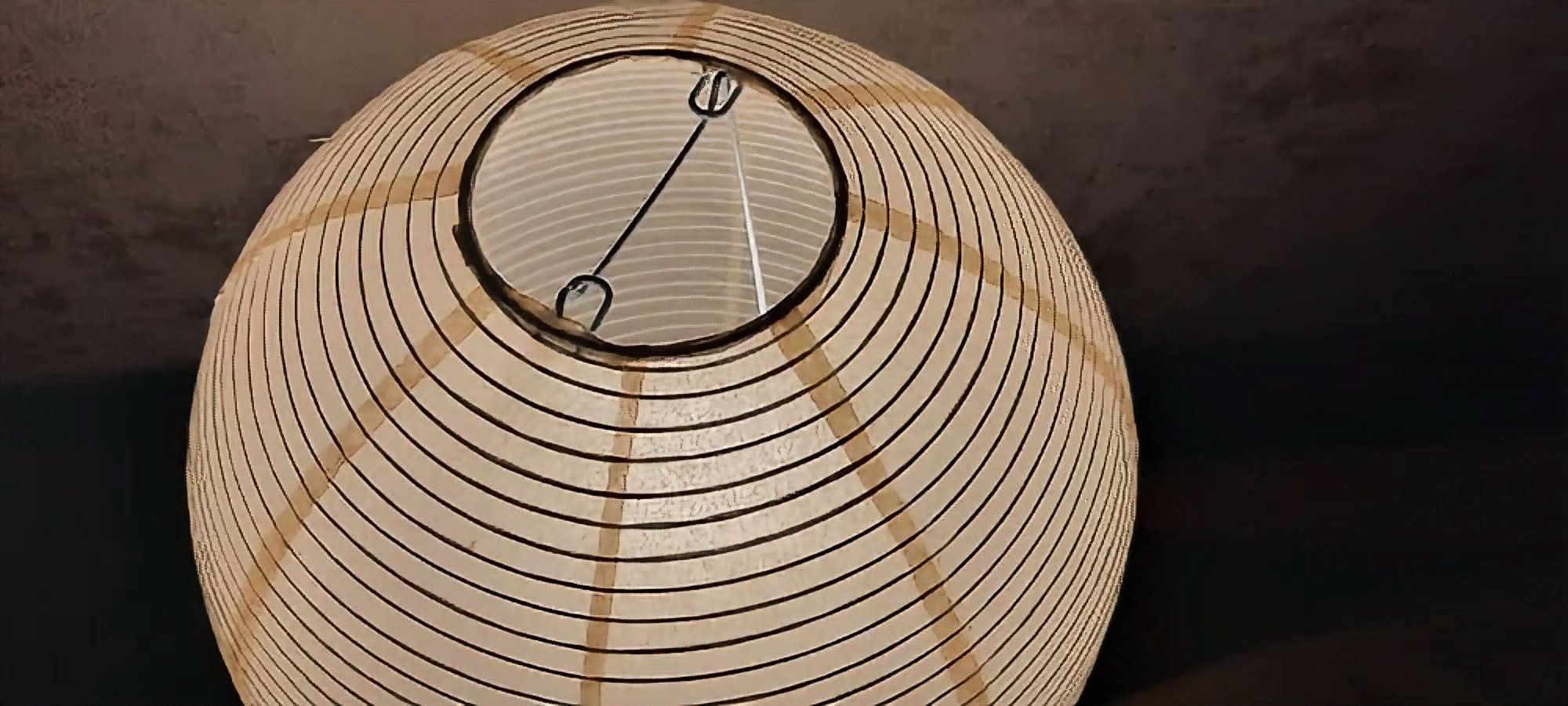 Paper Table Lamp Elongated: light beige paper lantern with black stripes and frame, home decor.