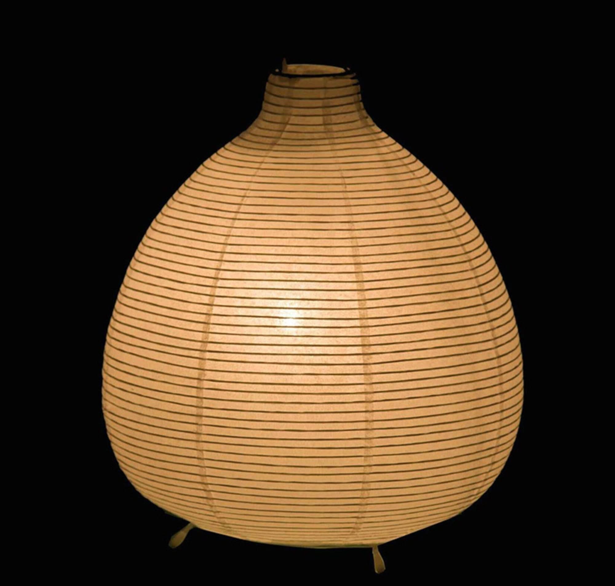 Teardrop paper table lamp, warm beige with black horizontal stripes, on black background.