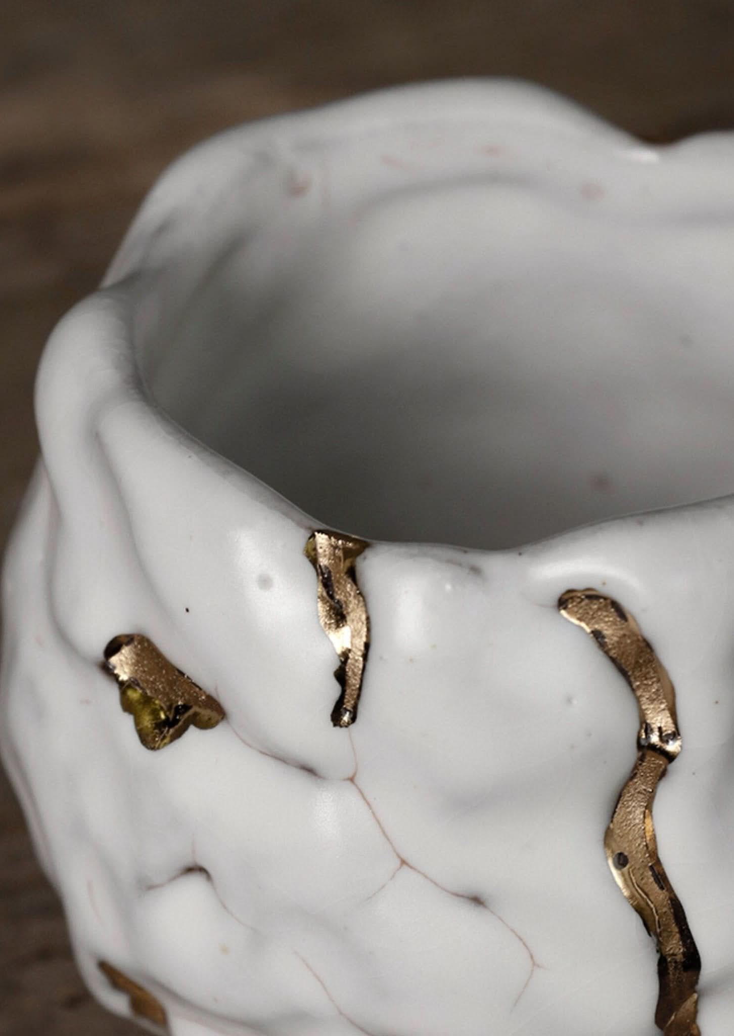 Porcelain white and gold glazed tea cup with Kintsugi repair, handmade in Japan.