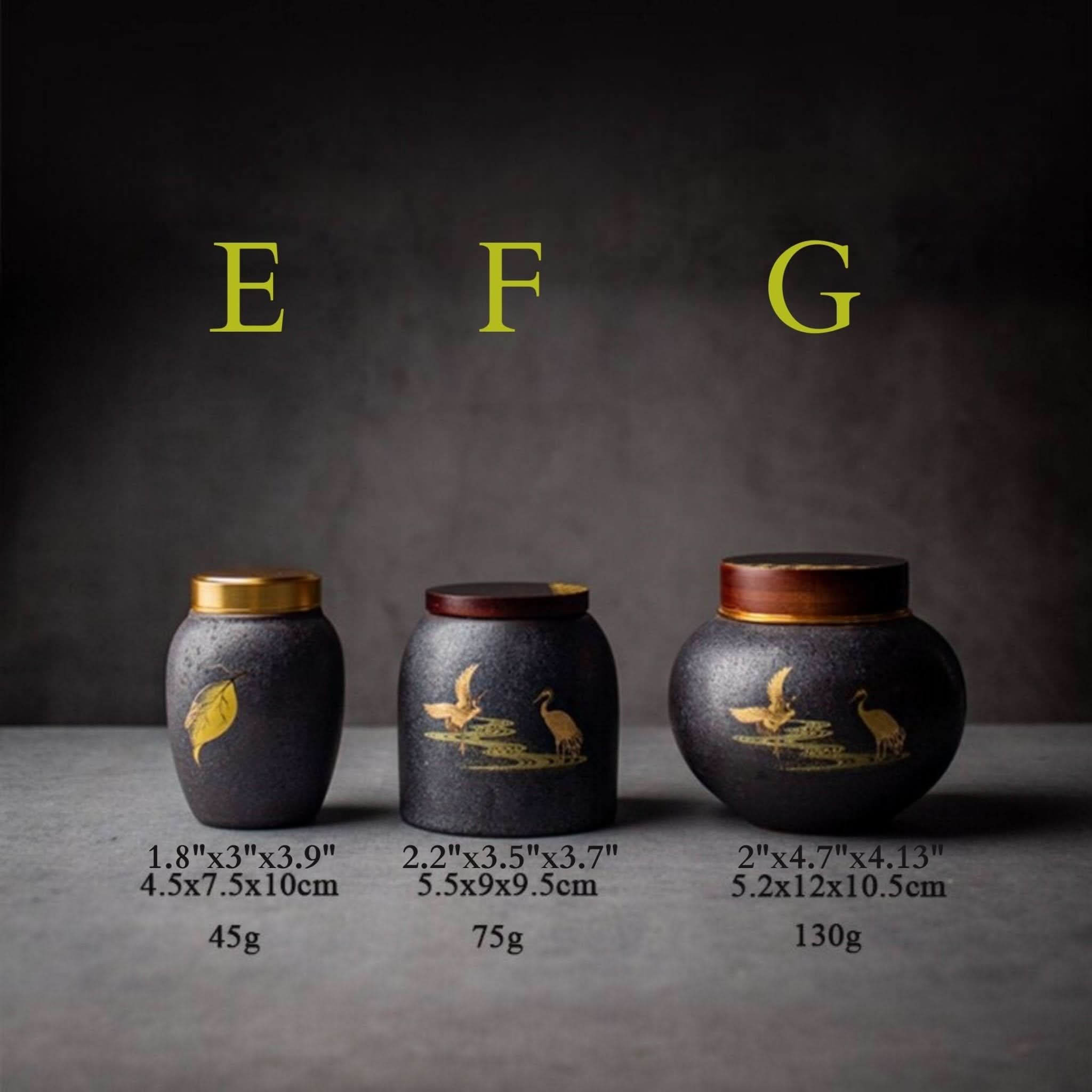 Black pottery jar with lid, featuring gold cranes & leaf design. Kitchen storage container.